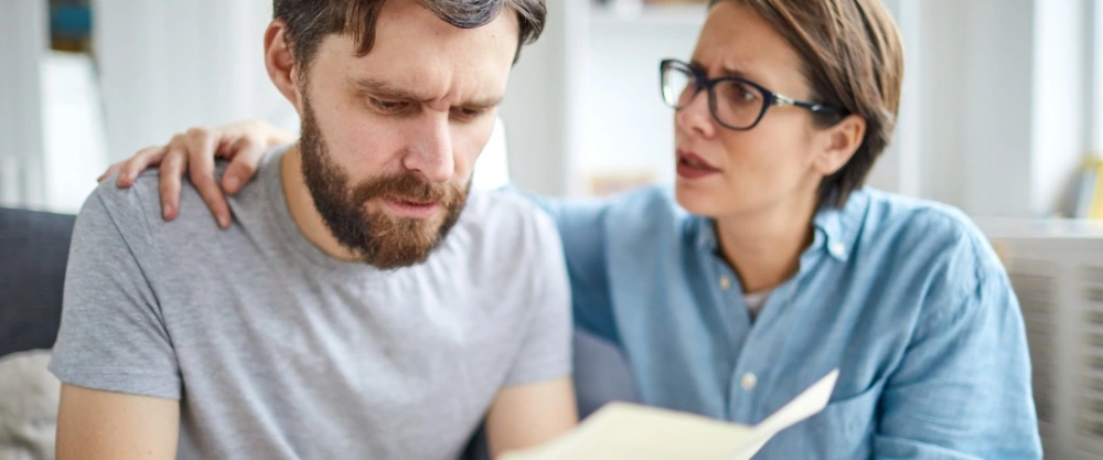 Afgewezen na een sollicitatie? 5 tips hoe je hiermee omgaat man afgewezen voor baan en is teleurgesteld en vrouw die troost met hand op schouder